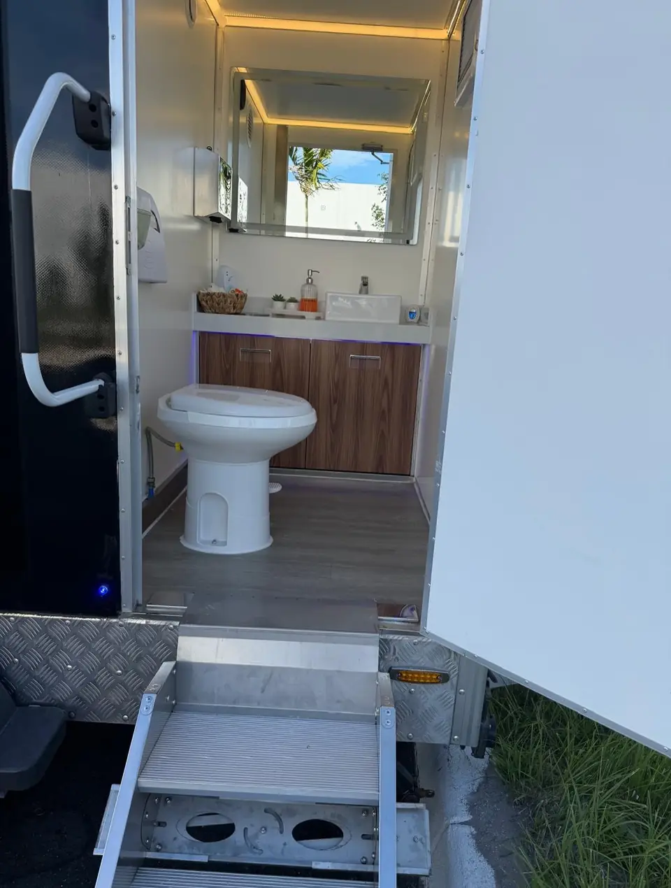 Restroom trailer interior with toilet and vanity